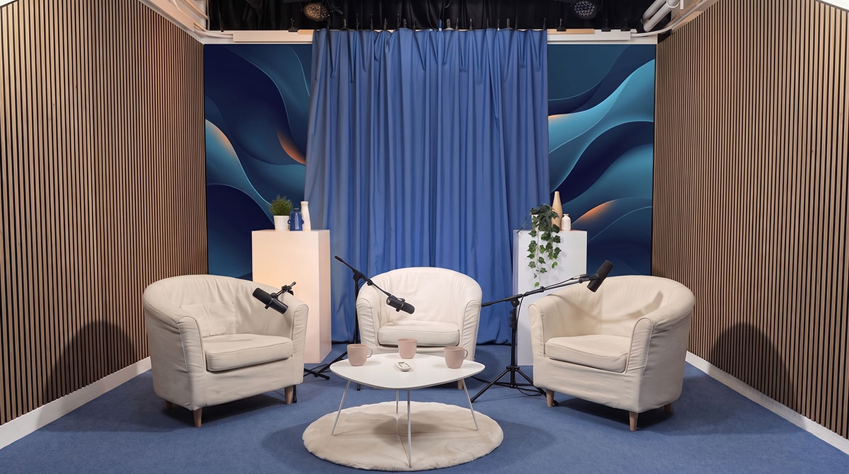 Set podcast con LED Wall, tenda blu e tre poltrone